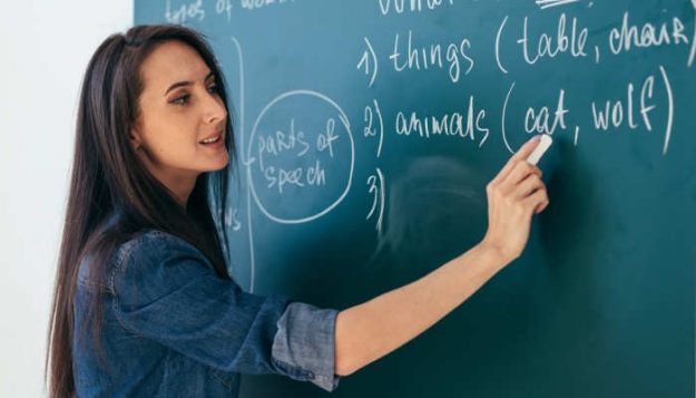 Student or teacher standing in front of the class blackboard